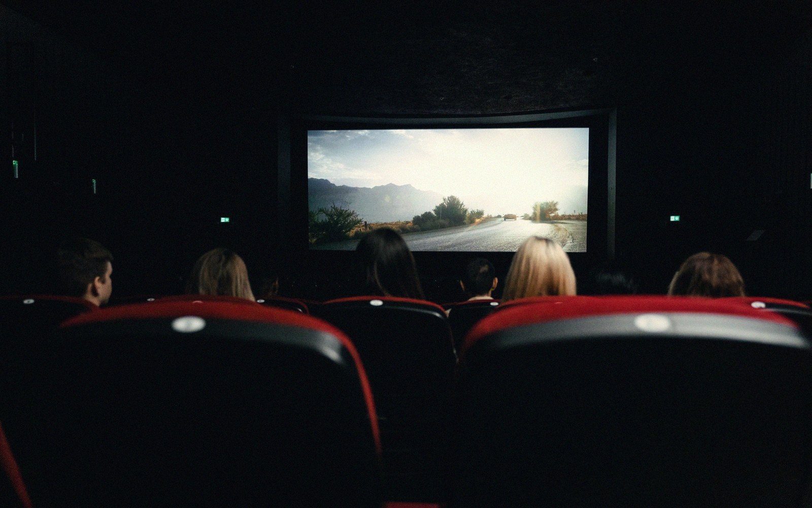 A darkened room, one lit screen, a person seated well back