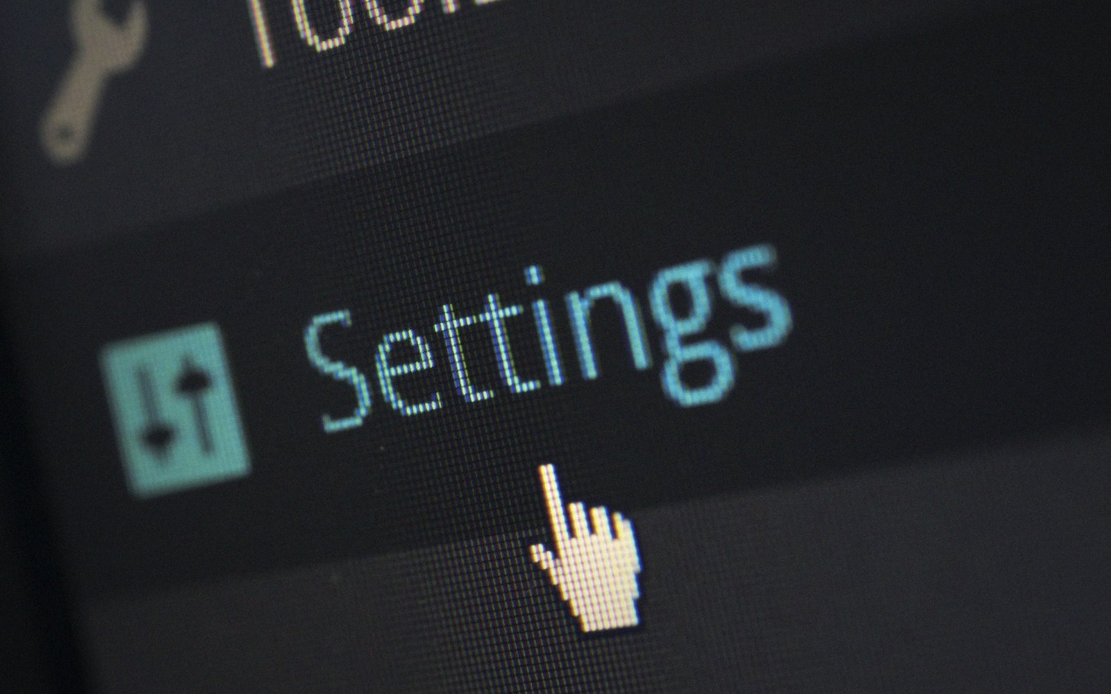 Close-up of a computer screen showing a cursor hovering over the settings menu option